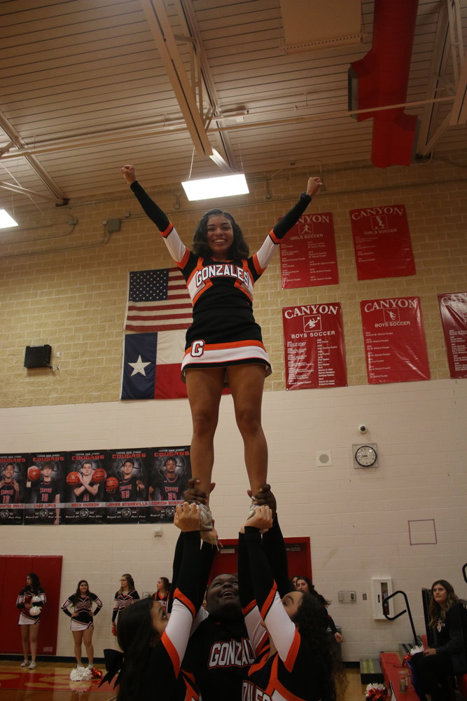 Senior Trinity Barr stands tall during a lift by her fellow Gonzales High School cheerleaders at Tuesday’s bi-district playoff game between the Apaches and the Wimberley Texans.