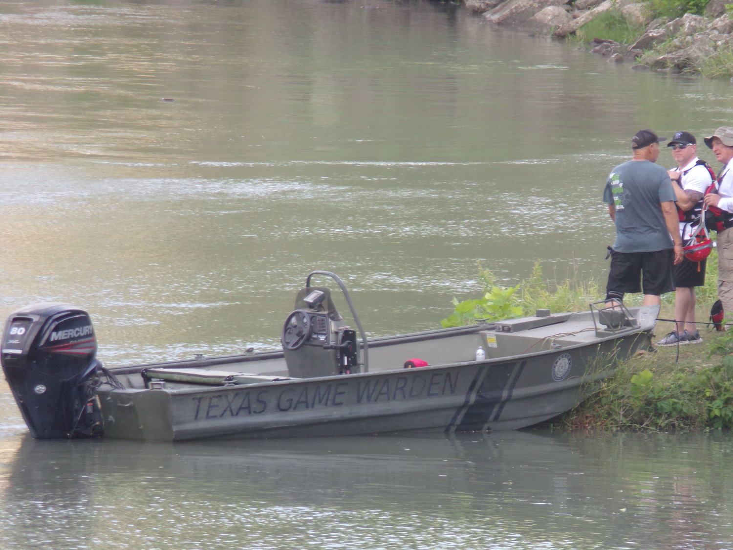 Game wardens look for a drowning victim in the Guadalupe River near the Gonzales dam.